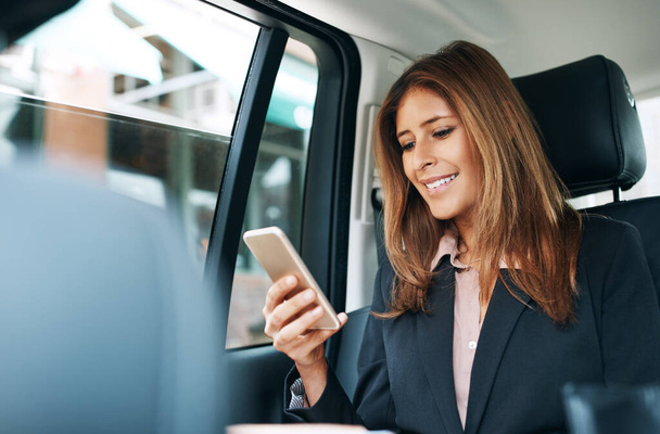 Συνδέσου και συνέχισε τις δουλειές σου. ώριμη επιχειρηματίας που χρησιμοποιεί κινητό τηλέφωνο στο πίσω κάθισμα αυτοκινήτου - Φωτογραφία, εικόνα