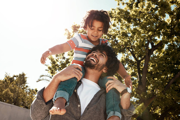 Uit om wat avontuur te beleven. een vader geeft zijn zoontje een ritje op de rug buiten - Foto, afbeelding