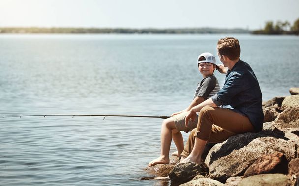 Το ψάρεμα είναι ακριβώς η ιδέα τους για διασκέδαση. Ένας πατέρας και ο γιος του ψαρεύουν μαζί. - Φωτογραφία, εικόνα
