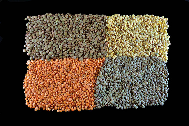 Four types of lentils forming a picture on a black background. - Foto, afbeelding