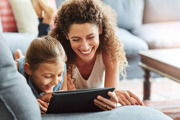 Technology connects them. a mother and her little daughter using a digital tablet together at home - Φωτογραφία, εικόνα