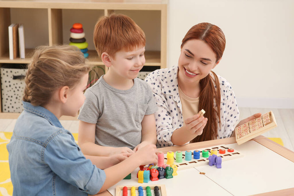 Šťastná matka a děti hrát s různými matematické herní sady na stole v místnosti. Studium matematiky s potěšením - Fotografie, Obrázek