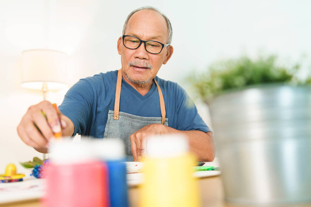 Asian Japanese Senior man in apron painting art at home. Watercolor, Leisure activity - Photo, Image