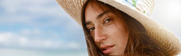 Portrait of woman in hat standing beach on the background of ocean. High quality photo - Foto, immagini