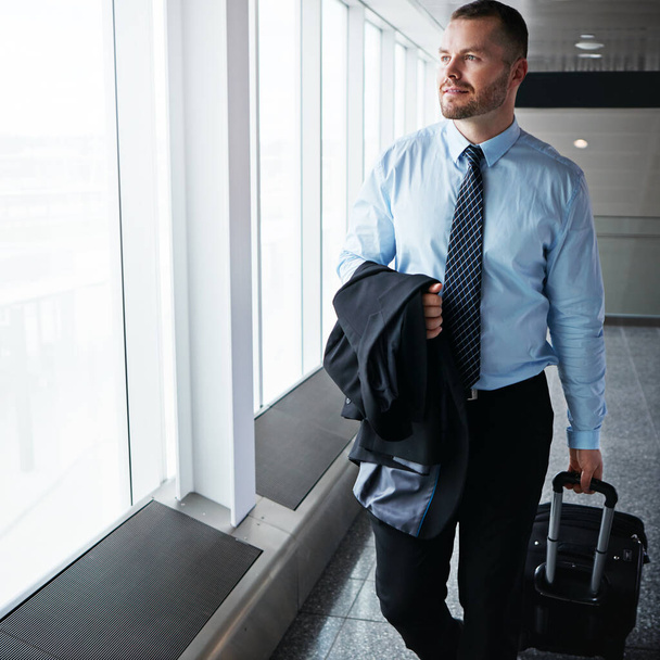 Time to head back to the office. an executive businessman walking through an airport during a business trip - Foto, imagen