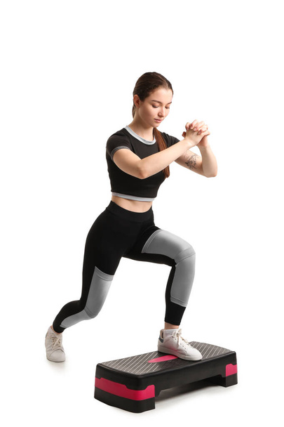 Sporty young woman training with stepper on white background - Zdjęcie, obraz