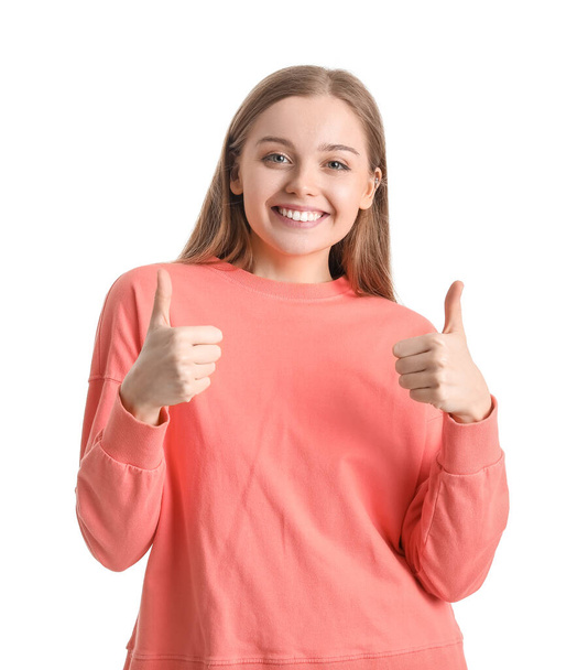 Молодая женщина в красной толстовке показывает большие пальцы вверх на белом фоне - Фото, изображение