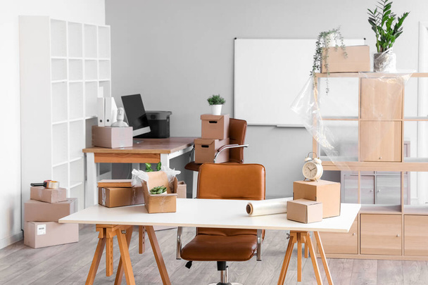 Workplace with cardboard boxes in office on moving day - Foto, Bild