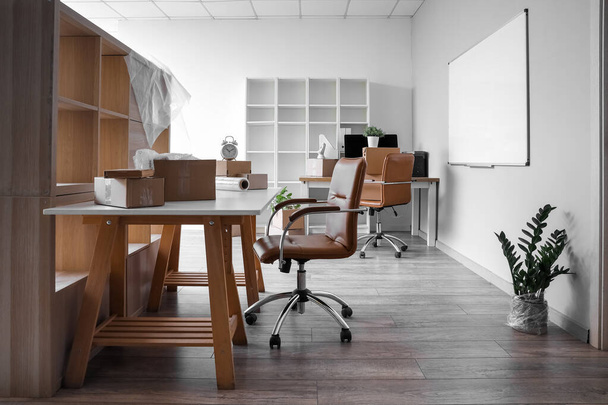 Locais de trabalho com caixas de papelão no escritório no dia em movimento - Foto, Imagem