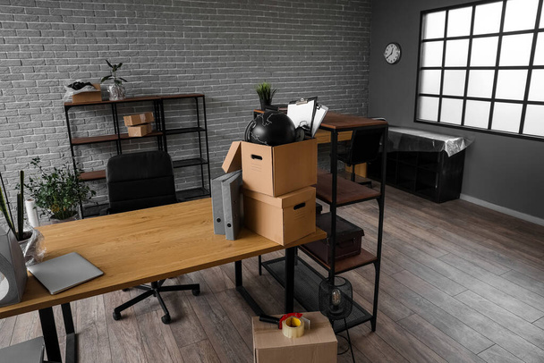 Lugares de trabajo con cajas de cartón en la oficina en el día en movimiento - Foto, Imagen