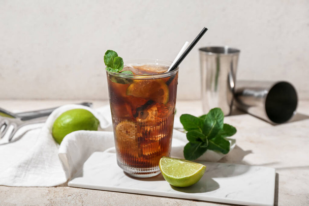 Glass of tasty Cuba Libre cocktail on light background - Photo, Image