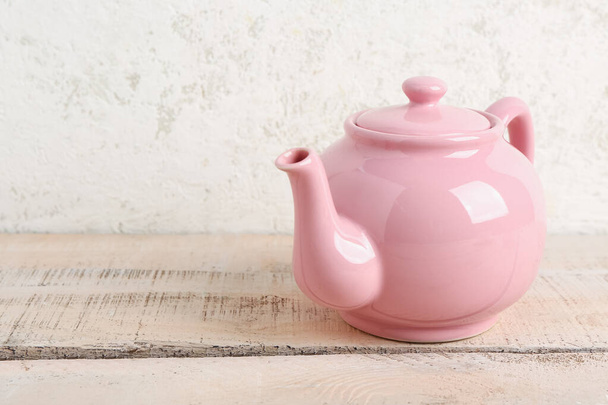 Cute ceramic teapot on white wooden table - Foto, afbeelding