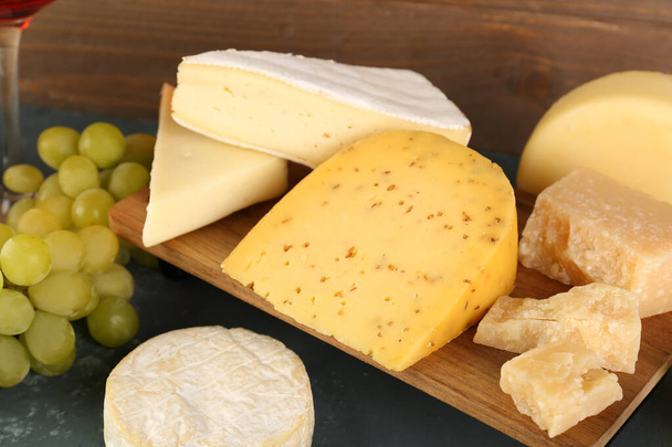 Wooden board with different types of cheese on table - Valokuva, kuva