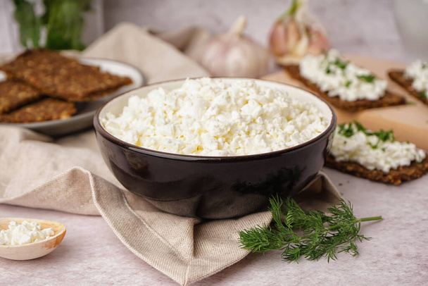 Bowl with tasty cottage cheese on light grunge background - Foto, immagini