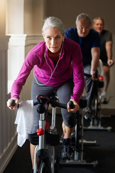 One leg at a time, we got this. a group of seniors having a spinning class at the gym - Foto, Bild