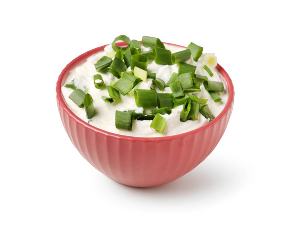 Bowl of tasty sour cream with green onion on white background - Foto, Imagem