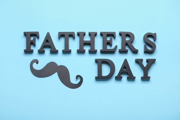 Text HAPPY FATHER'S DAY with paper mustache on blue background - 写真・画像