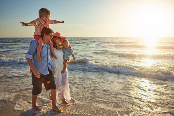 Su forma favorita de pasar el verano. una joven familia disfrutando de un día en la playa - Foto, Imagen