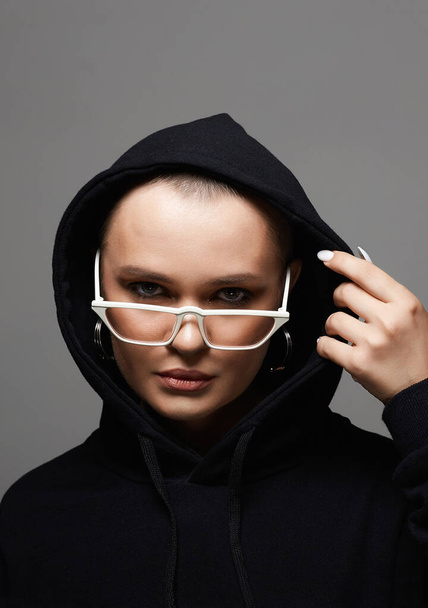 beautiful young woman wearing Hoodie and fashionable glasses. stylish bald girl in Hood - Фото, изображение