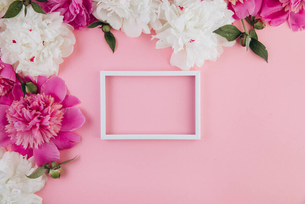 Σύνθεση από λευκές και ροζ παιώνιες και λευκό άδειο πλαίσιο με αντιγραφικό χώρο, όμορφο φλοράλ φόντο, μόδα, glamour, flat lay - Φωτογραφία, εικόνα
