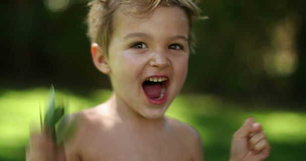 Happy excited infant toddler child jumping up and down outdoors. Kid receiving news feeling joy - Foto, Bild