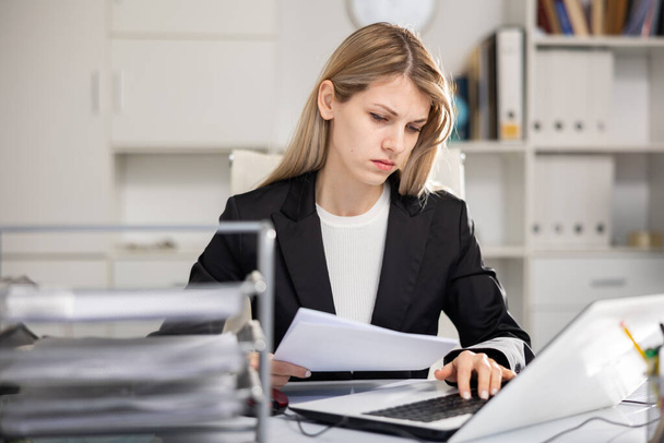 Portrait of unhappy business woman working on laptop, she has problems at work in modern office - Foto, Bild