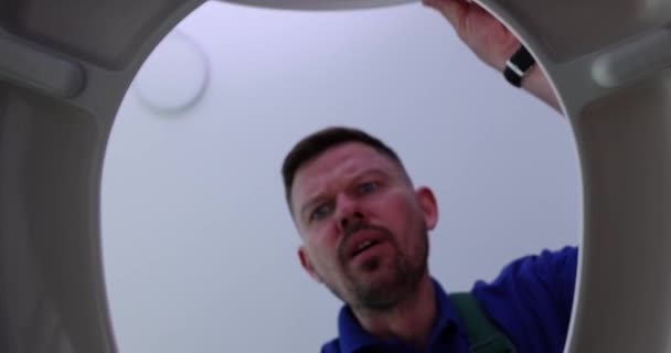 Surprised men plumbers opening toilet lid at home bottom view 4k movie. Lost things in toilet concept - Footage, Video