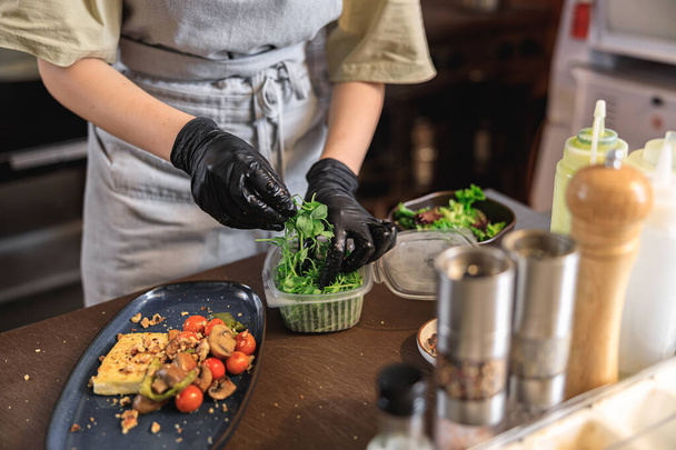 Chef décore le repas préparé avec des légumes verts sur la cuisine du restaurant. Photo de haute qualité - Photo, image