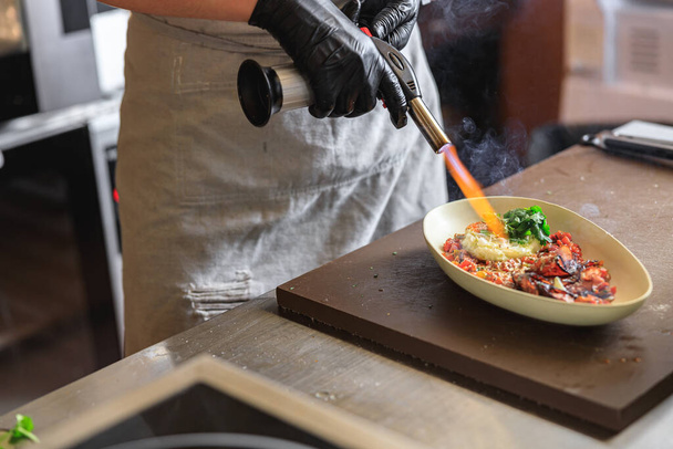 Chef aquecer prato com fogo na cozinha do restaurante antes de servir para o cliente. Foto de alta qualidade - Foto, Imagem