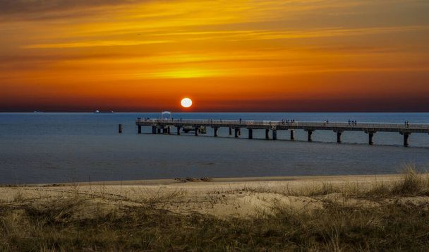 Sonnenuntergang über der Ostsee mit Brücke - Foto, Bild