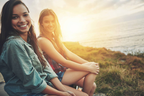 Just a little sunshine to brighten up our day. Cropped portrait of two friends on a road trip to the beach at sunset - Fotoğraf, Görsel