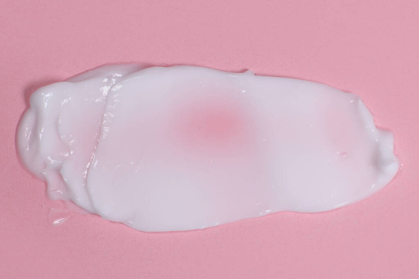 Crema facial o corporal untada sobre fondo rosa - Foto, Imagen