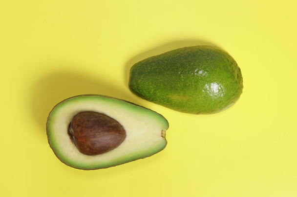 maturo avocado taglio verde fresco su sfondo giallo - Foto, immagini