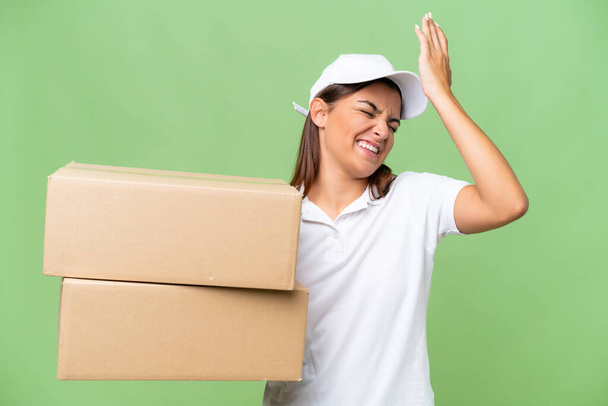 Delivery caucasian woman holding boxes isolated on green chroma background has realized something and intending the solution - Photo, Image