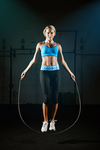 Skip your way to a healthier lifestyle. a young woman jumping rope in a gym - Foto, imagen