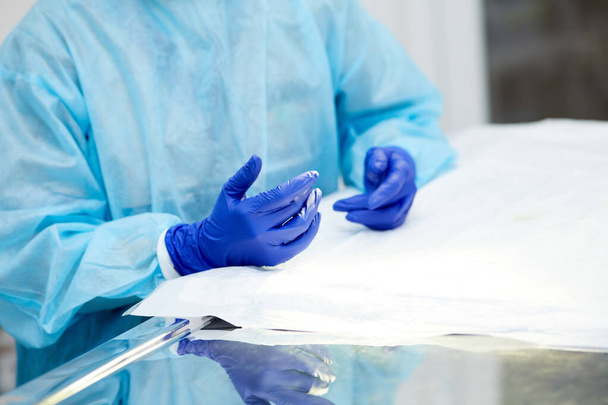 Doctors, surgeons hands holding professional medical tools. Doctor wearing protective gloves and apron. Concept of medicine, hospital, healthcare, treatment, profession - Foto, Imagem