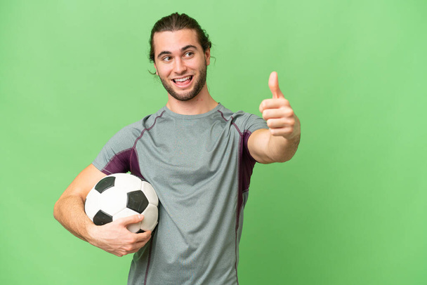 Joven jugador de fútbol guapo hombre sobre fondo aislado dando un gesto pulgares hacia arriba - Foto, Imagen