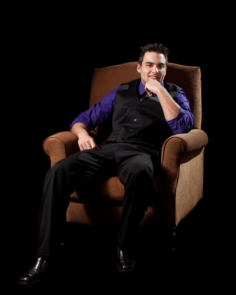 Well dressed man in chair. Studio shot over black. - Foto, afbeelding