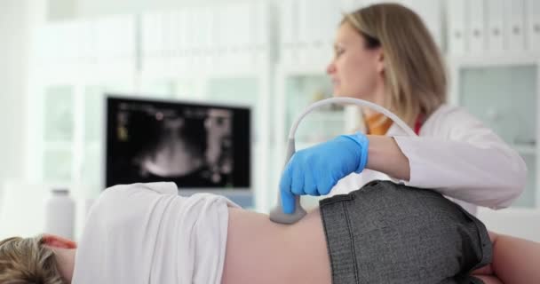 Lekarz sprawdza chore nerki dziewczynki ze sprzętem ultrasonograficznym. Wykwalifikowany lekarz patrzy na ekran, aby zbadać stan narządu w zwolnionym tempie - Materiał filmowy, wideo