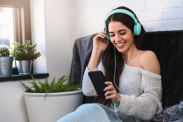 gyönyörű fiatal nő hallgat zenét fejhallgató otthon - Fotó, kép