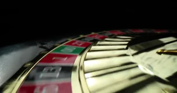 Τροχός με πολύχρωμα κύτταρα και αριθμούς περιστρέφεται και σταματά σε σκοτεινό φόντο. Οι παίκτες παίζουν ρουλέτα παιχνίδι δοκιμάζοντας τύχη στο σύγχρονο καζίνο - Πλάνα, βίντεο