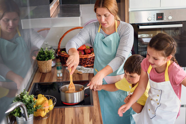 madre, hija e hijo cocinando pastelería juntos, trabajando con masa - Foto, Imagen