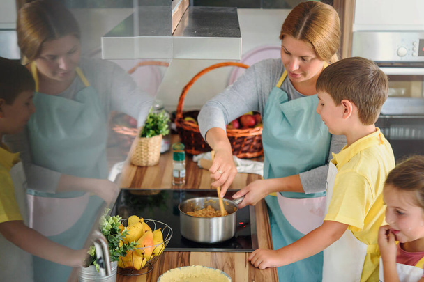 madre, figlia e figlio cucinano insieme la pasticceria, lavorando con la pasta - Foto, immagini
