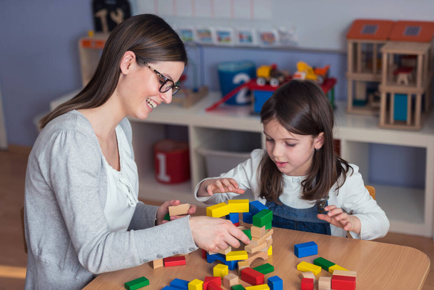 tanár és gyermek játszik játék építőkockák - Fotó, kép