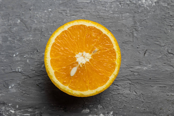A half of an orange on a gray background - Zdjęcie, obraz