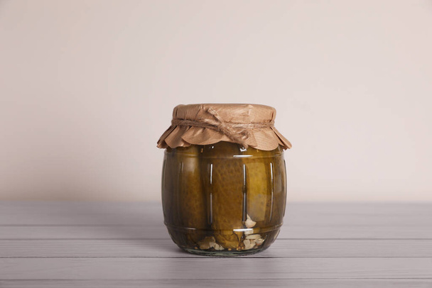 Jar with pickled cucumbers on white wooden table - Foto, Imagem