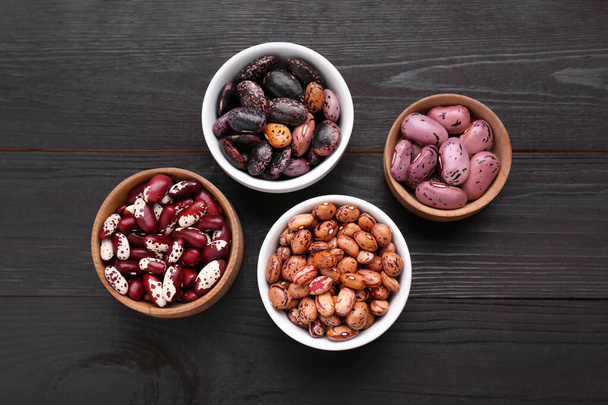 Different kinds of dry kidney beans on wooden table, flat lay - Φωτογραφία, εικόνα