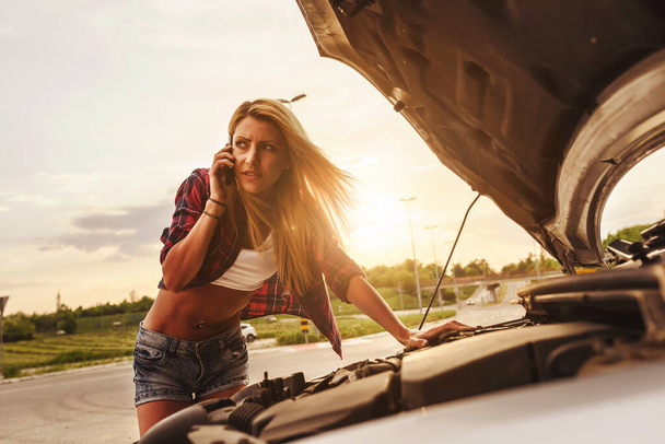 mujer joven con el coche roto en la carretera  - Foto, Imagen