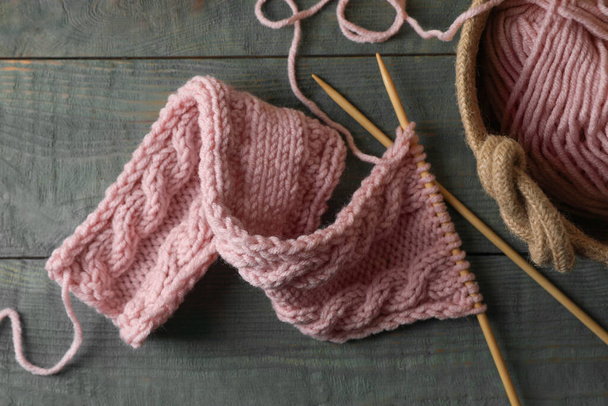 Soft pink woolen yarn, knitting and needles on wooden table, flat lay - Foto, afbeelding