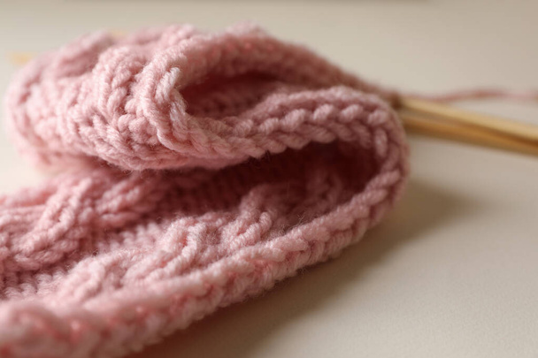 Pink knitting and needles on beige background, closeup - Foto, afbeelding